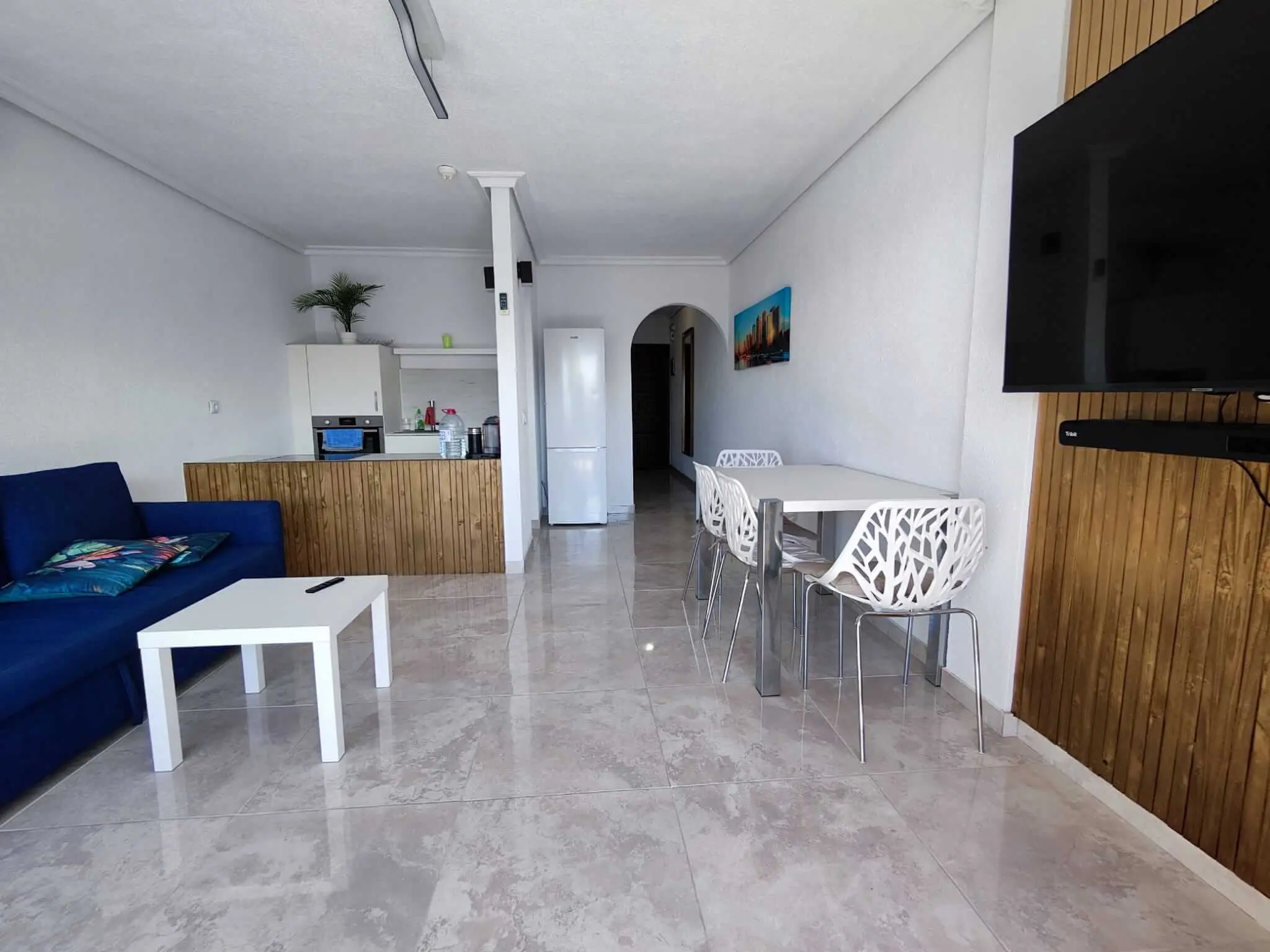 Bright and modern living area with open kitchen in a one-bedroom apartment at Park Albatros